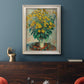 Impressionist floral painting of artichoke flowers by Claude Monet in an ornate champagne frame displayed in a dark-toned interior setting.