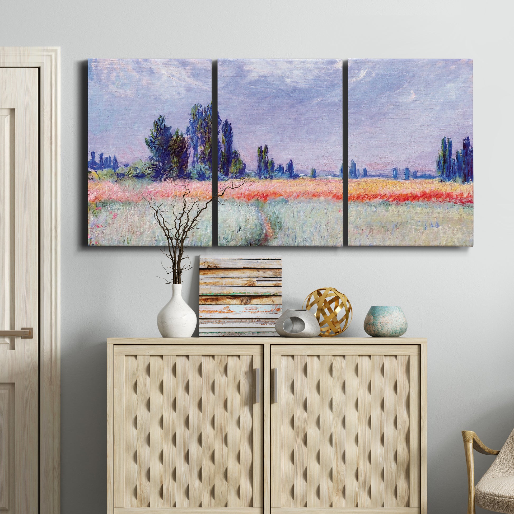 Three-panel canvas wall art featuring flowering field with poppies, displayed above a cabinet in an entryway.