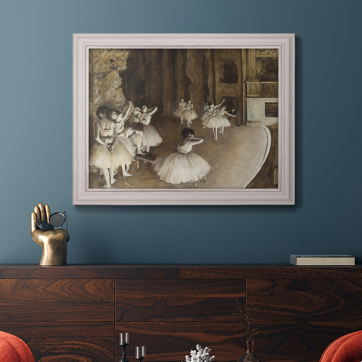 Impressionist ballet rehearsal scene by Edgar Degas in an ornate weathered white frame displayed in a dark-toned interior setting.