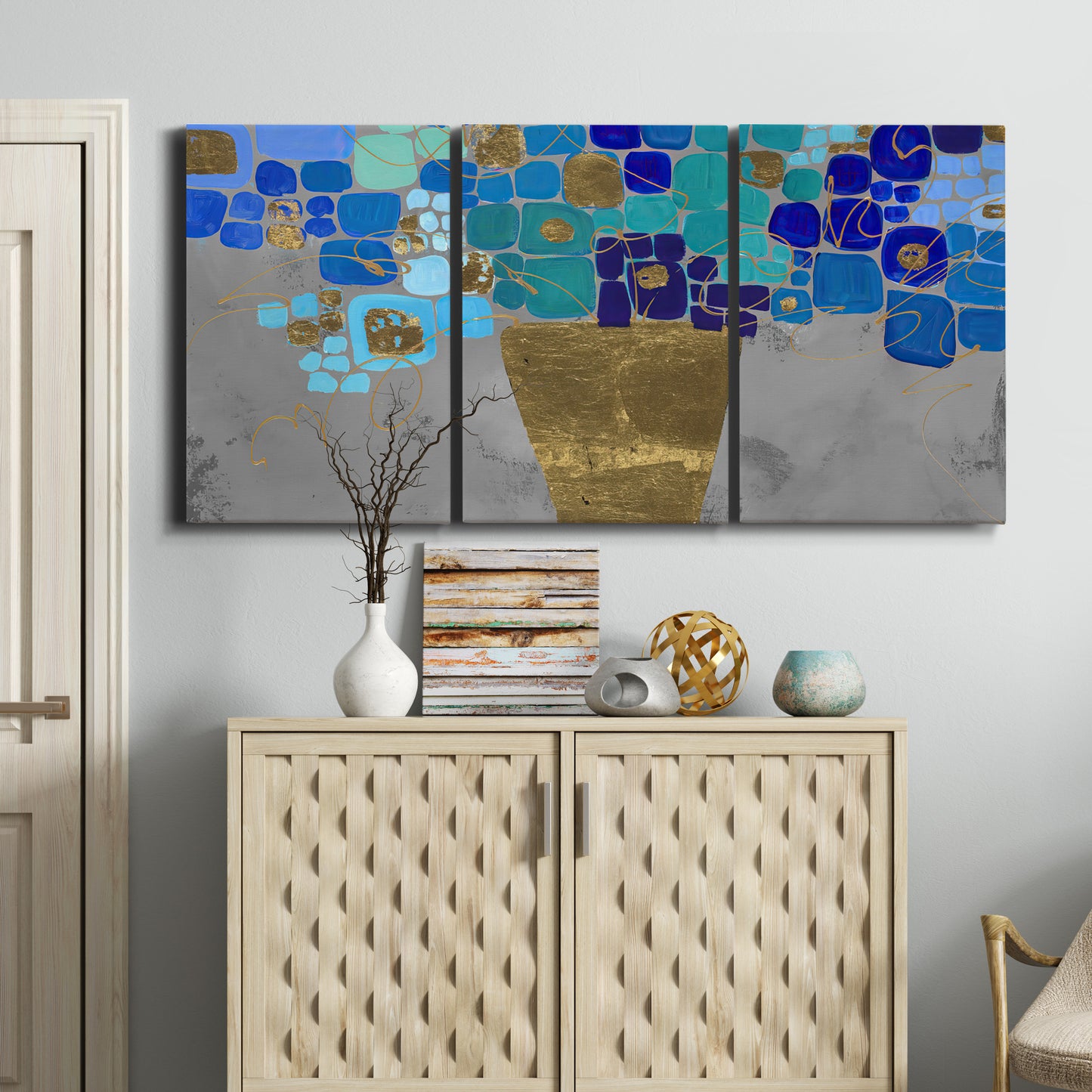 Three-panel canvas wall art featuring blue floral abstract botanical expression, displayed above a cabinet in an entryway.