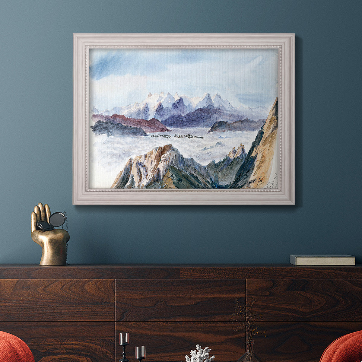 Impressionist alpine mountain landscape by John Singer Sargent in an ornate weathered white frame displayed in a dark-toned interior setting.