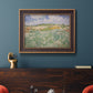 Impressionist countryside landscape near Auvers by Vincent van Gogh in an ornate bronzed mahogany wood frame displayed in a dark-toned interior setting.
