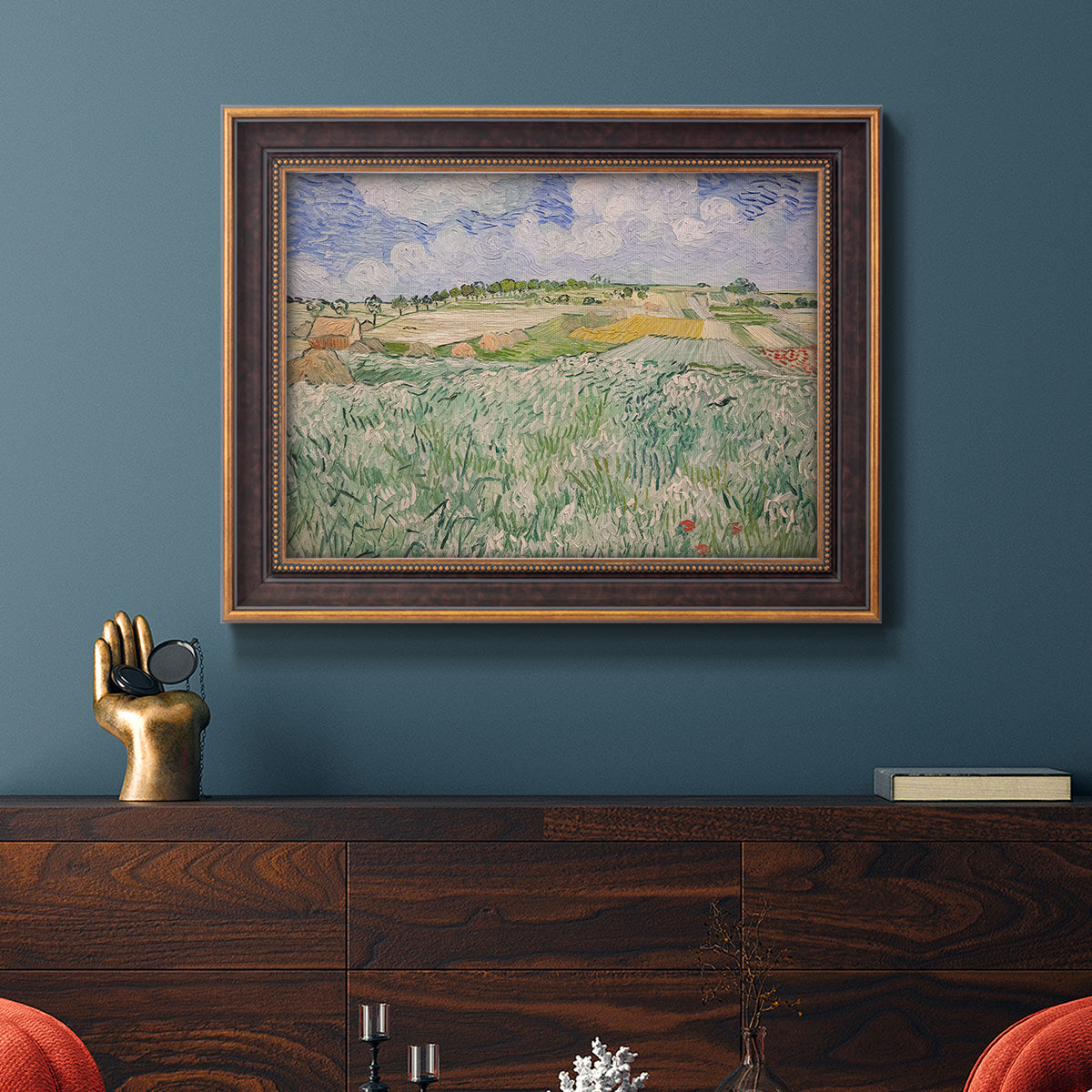Impressionist countryside landscape near Auvers by Vincent van Gogh in an ornate bronzed mahogany wood frame displayed in a dark-toned interior setting.