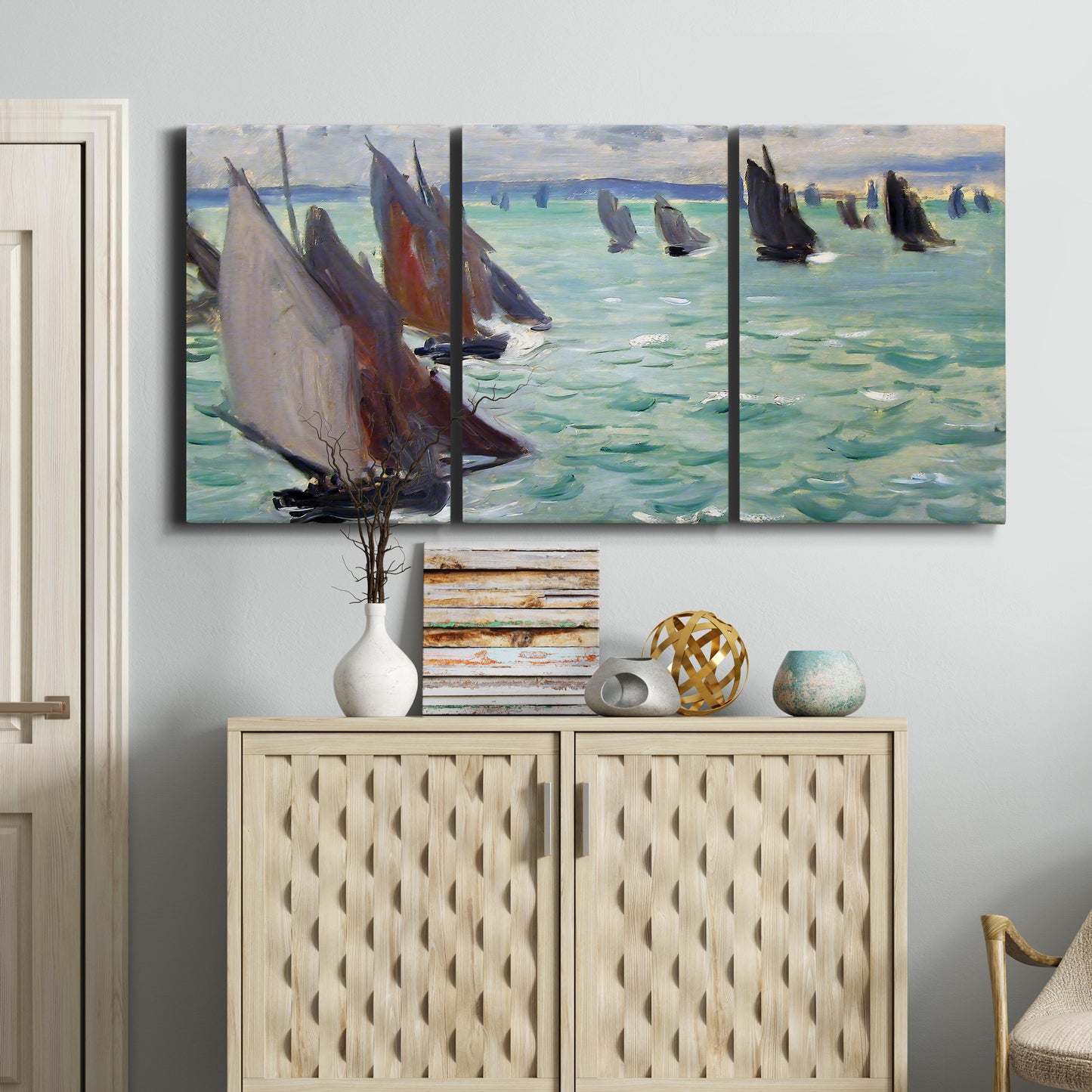 Three-panel canvas wall art featuring sailboat regatta near coastal village, displayed above a cabinet in an entryway.