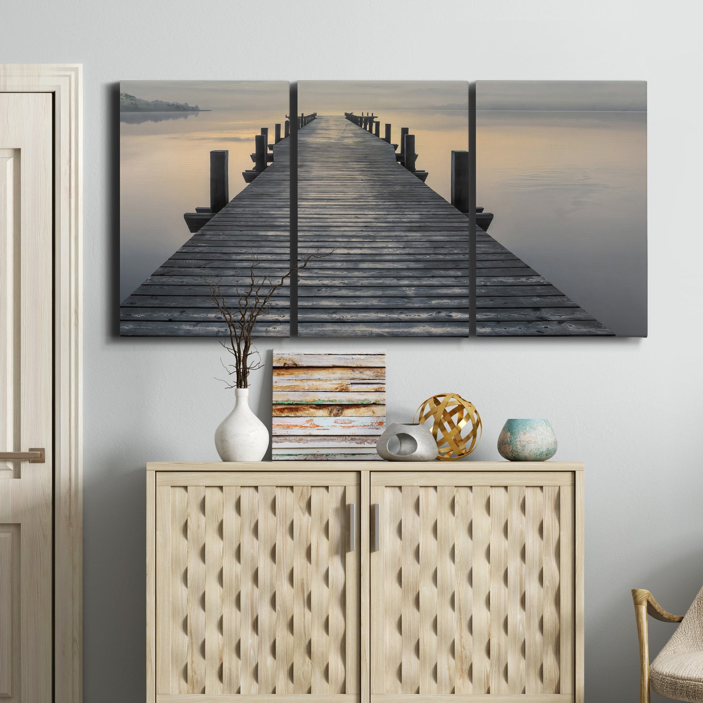 Three-panel canvas wall art featuring sunset over water photograph, displayed above a cabinet in an entryway.