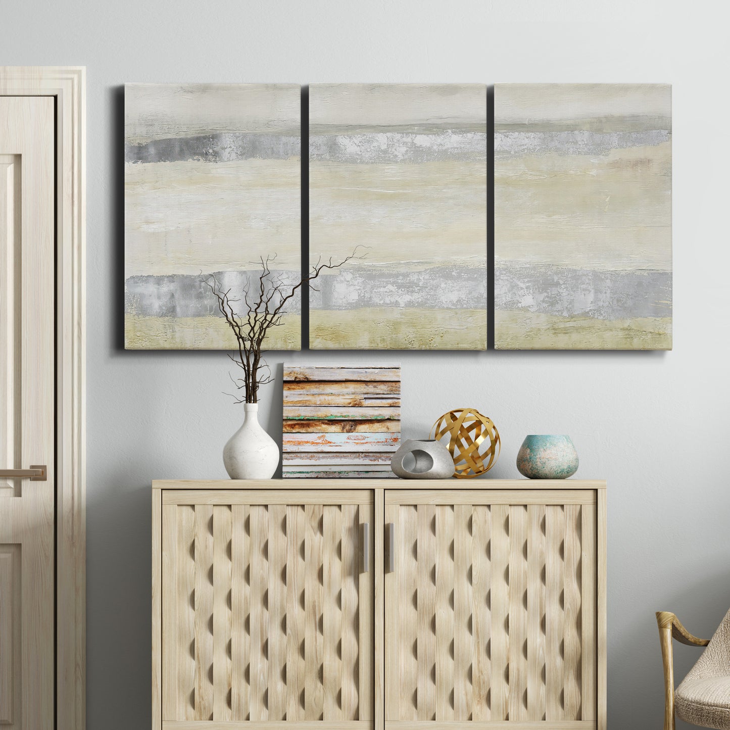 Three-panel canvas wall art featuring minimal abstract storm movement, displayed above a cabinet in an entryway.