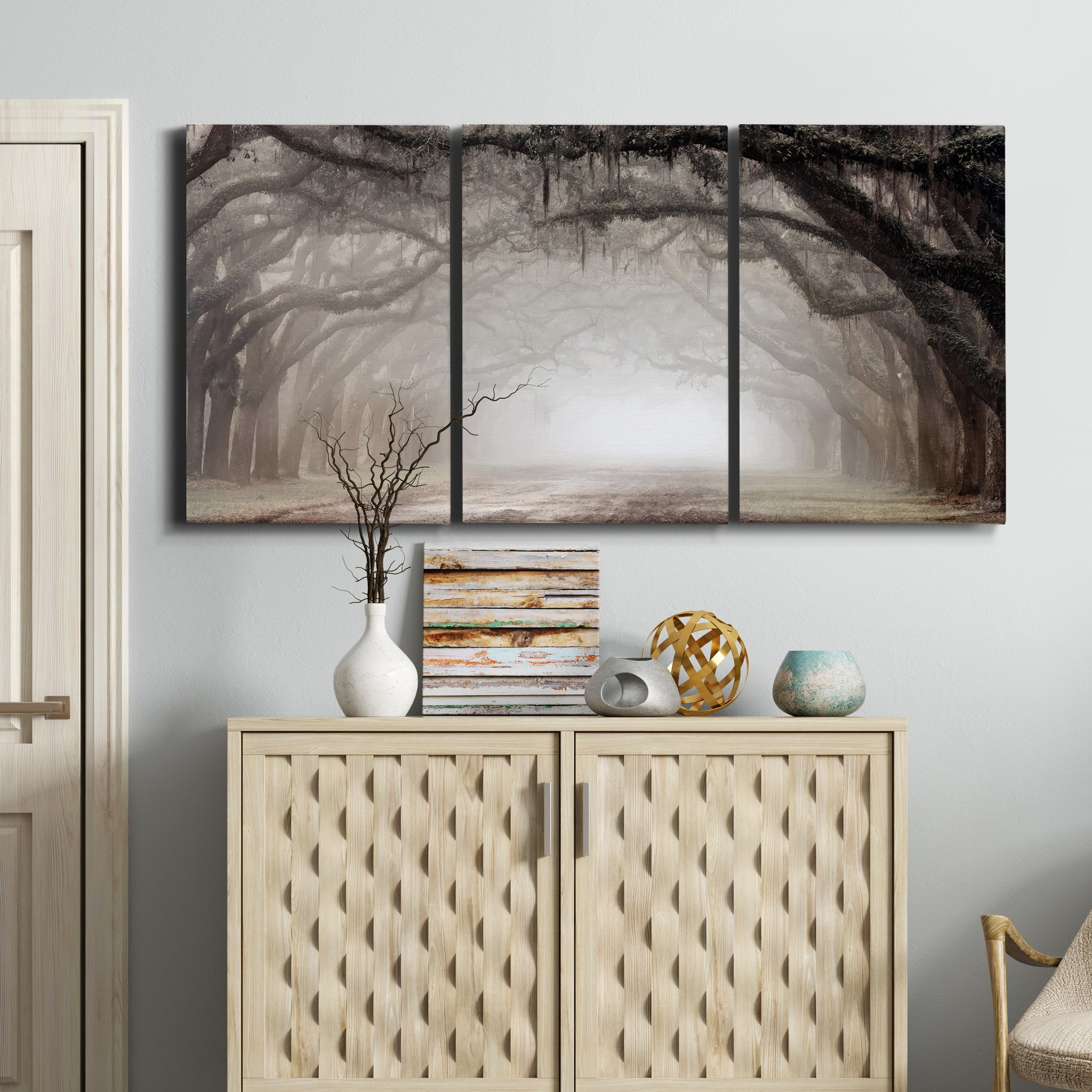 Three-panel canvas wall art featuring tree lined plantation road, displayed above a cabinet in an entryway.