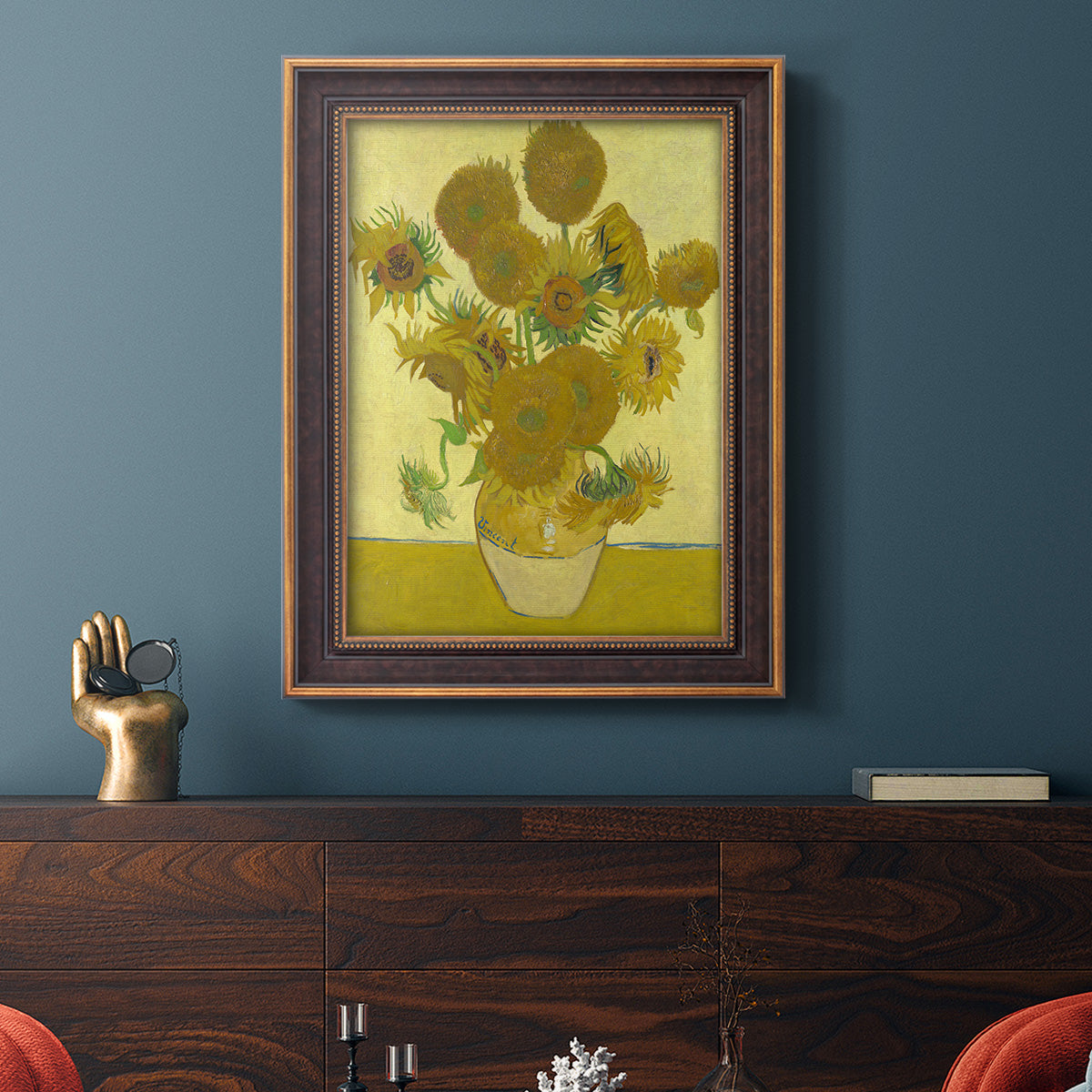 Impressionist sunflower still life painting by Vincent van Gogh in an ornate bronzed mahogany wood frame displayed in a dark-toned interior setting.