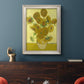 Impressionist sunflower still life painting by Vincent van Gogh in an ornate champagne frame displayed in a dark-toned interior setting.