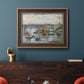 Impressionist river bridge scene on an overcast day by Claude Monet in an ornate bronzed mahogany wood frame displayed in a dark-toned interior setting.