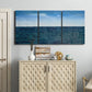 Three-panel canvas wall art featuring open water landscape with wide horizon, displayed above a cabinet in an entryway.