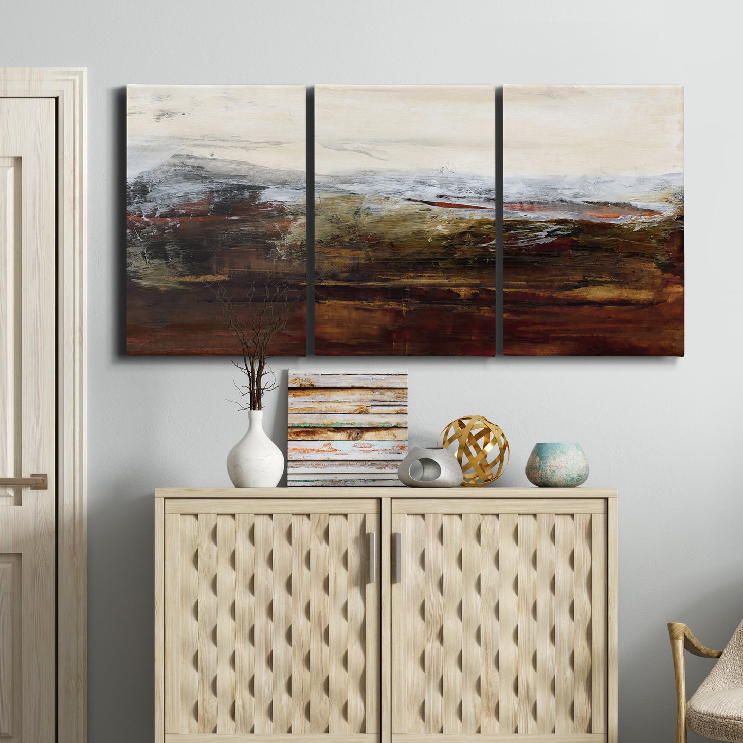 Three-panel canvas wall art featuring rustic abstract landscape exploration, displayed above a cabinet in an entryway.