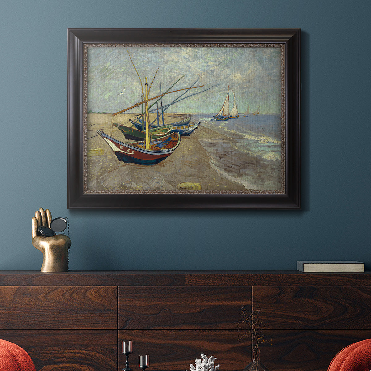 Impressionist coastal fishing boats scene by Vincent van Gogh in an ornate black frame with gilded inner detail displayed in a dark-toned interior setting.