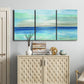 Three-panel canvas wall art featuring vast open blue ocean horizon, displayed above a cabinet in an entryway.
