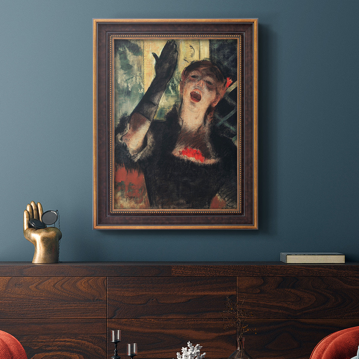 Impressionist portrait of a café singer by Edgar Degas in an ornate bronzed mahogany wood frame displayed in a dark-toned interior setting.