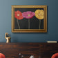 Contemporary poppy flower artwork in an ornate traditional gold frame displayed in a dark-toned interior setting.