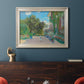 Impressionist residential landscape at Argenteuil by Claude Monet in an ornate champagne frame displayed in a dark-toned interior setting.