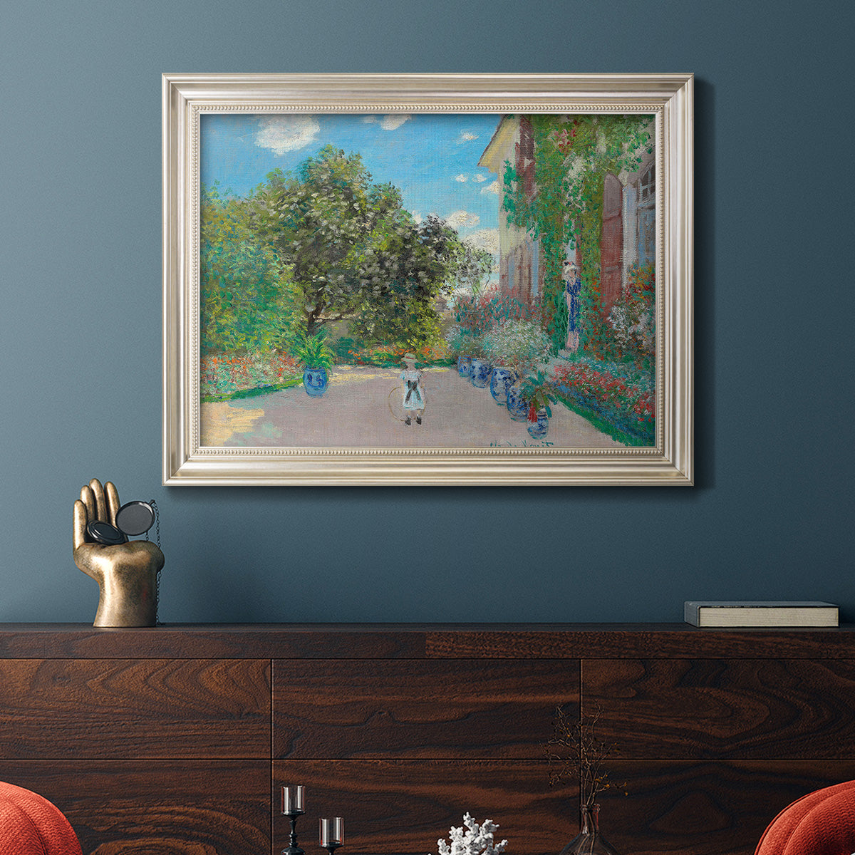 Impressionist residential landscape at Argenteuil by Claude Monet in an ornate champagne frame displayed in a dark-toned interior setting.
