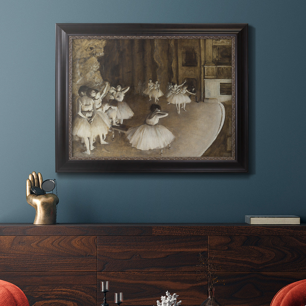Impressionist ballet rehearsal scene by Edgar Degas in an ornate black frame with gilded inner detail displayed in a dark-toned interior setting.