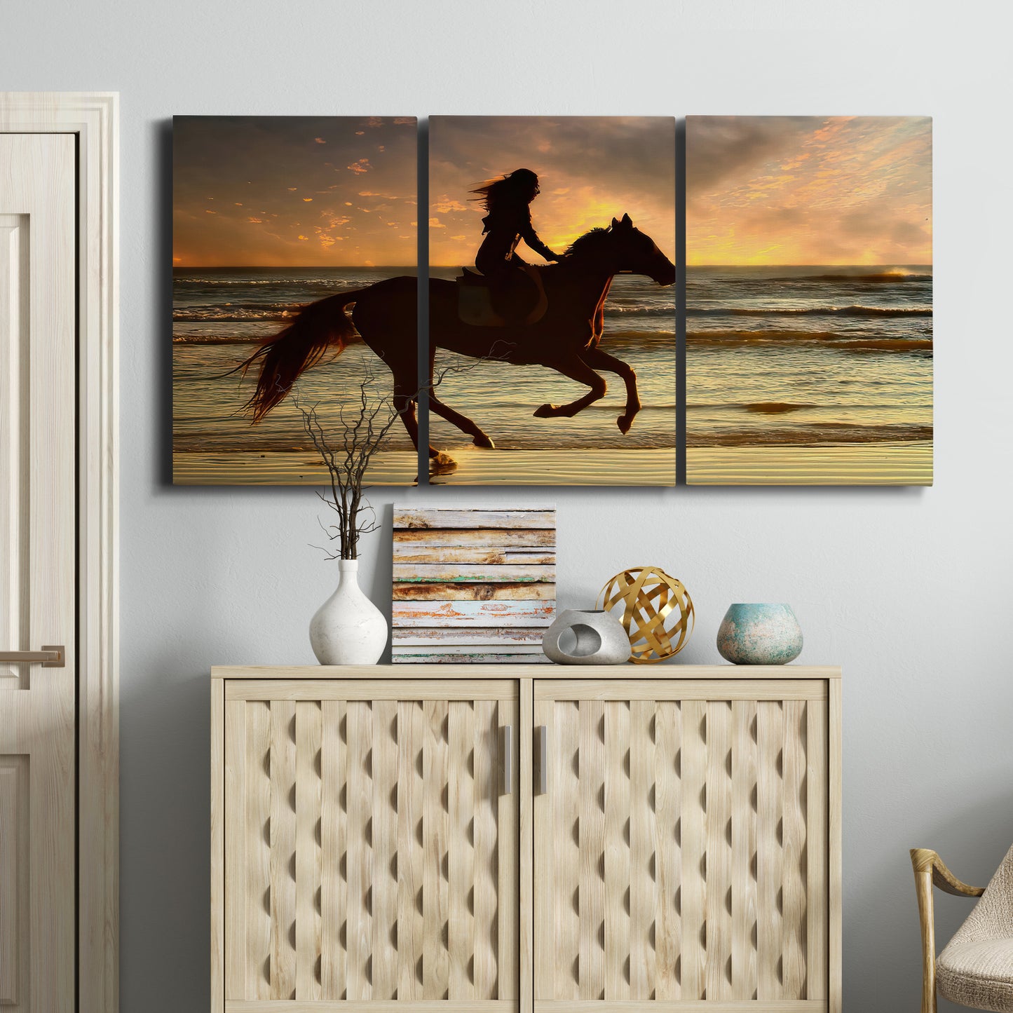 Three-panel canvas wall art featuring running horse along beach photograph, displayed above a cabinet in an entryway.