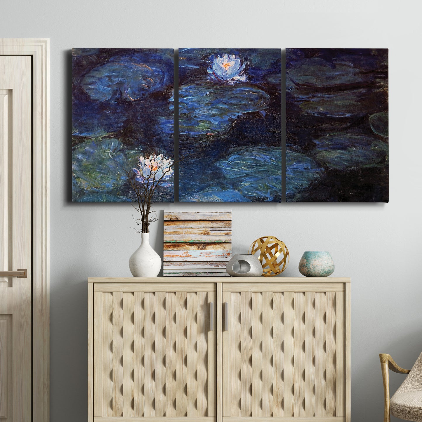 Three-panel canvas wall art featuring deep blue water lily reflections, displayed above a cabinet in an entryway.