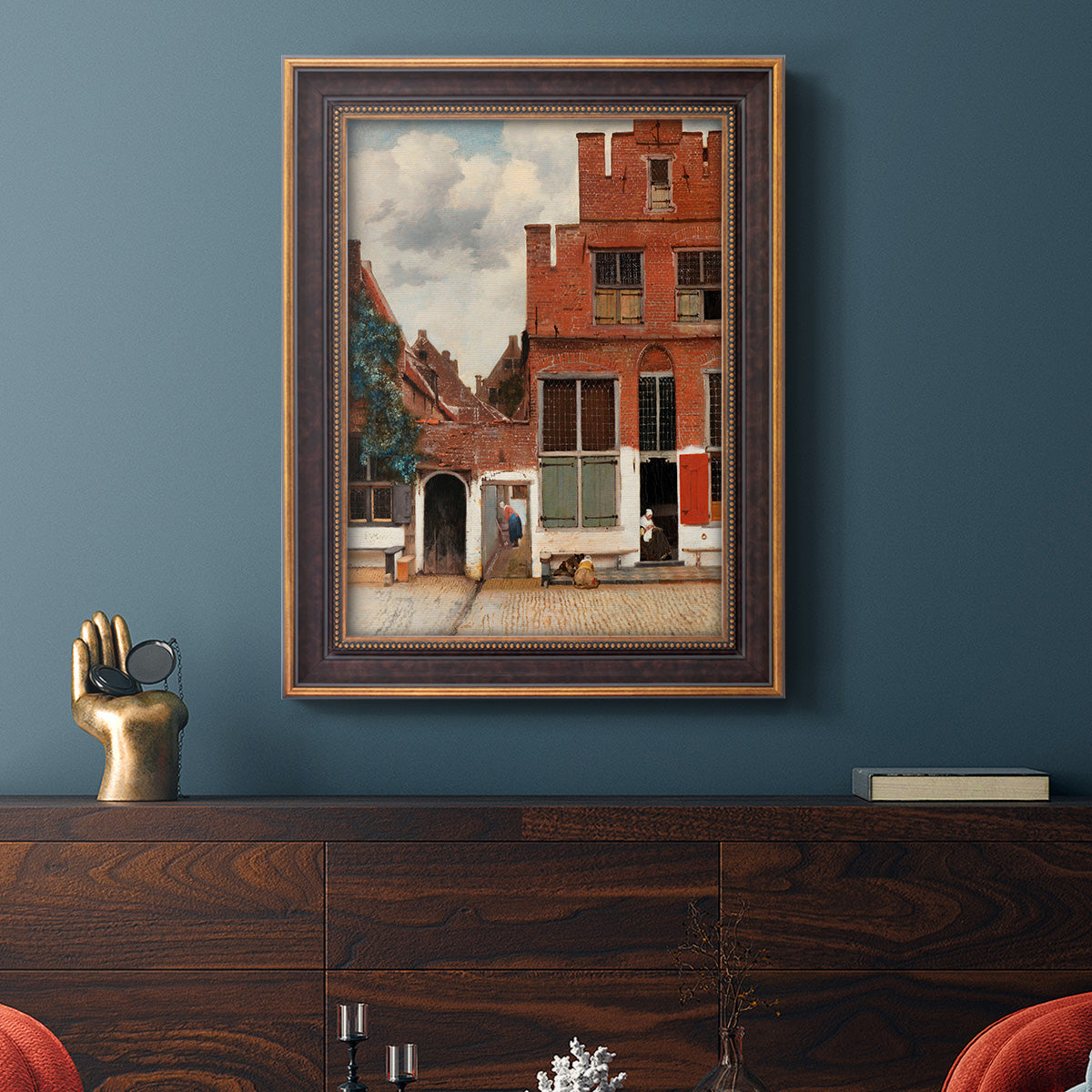 Realist city street scene by Johannes Vermeer in an ornate bronzed mahogany wood frame displayed in a dark-toned interior setting.