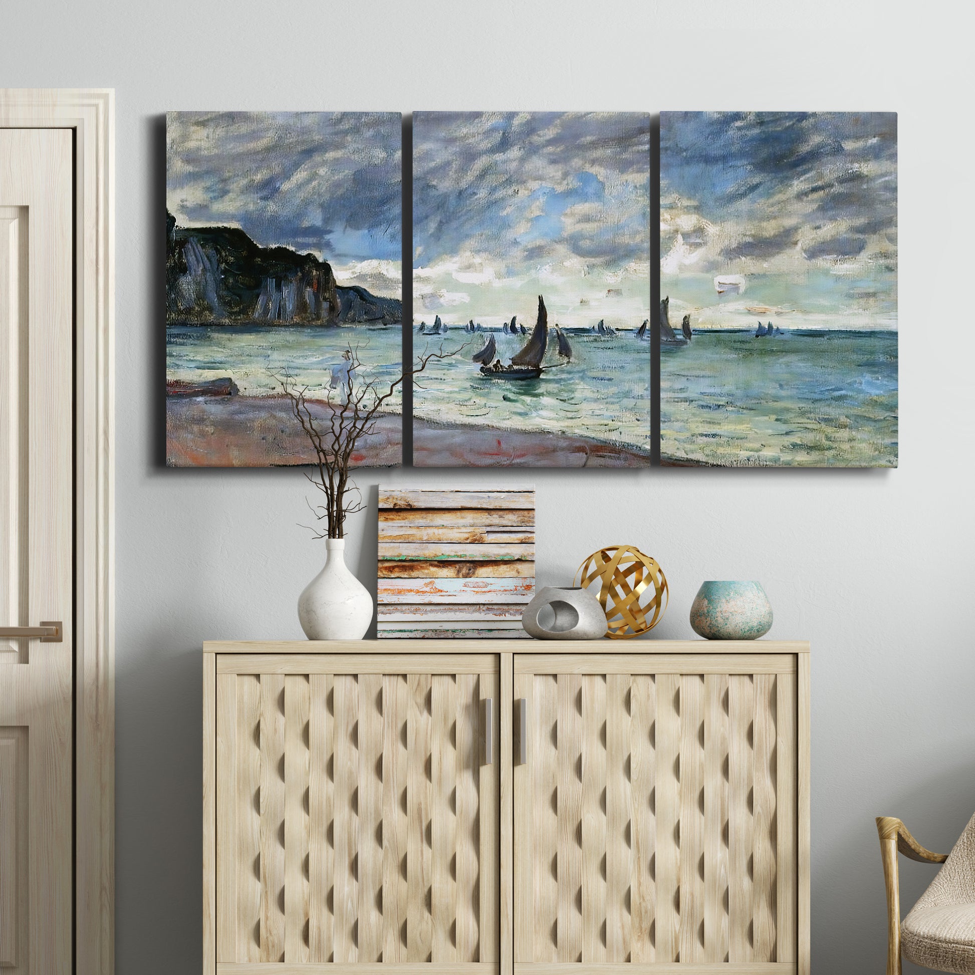 Three-panel canvas wall art featuring figures walking along sandy shoreline, displayed above a cabinet in an entryway.