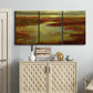 Three-panel canvas wall art featuring coastal shoreline with warm light, displayed above a cabinet in an entryway.