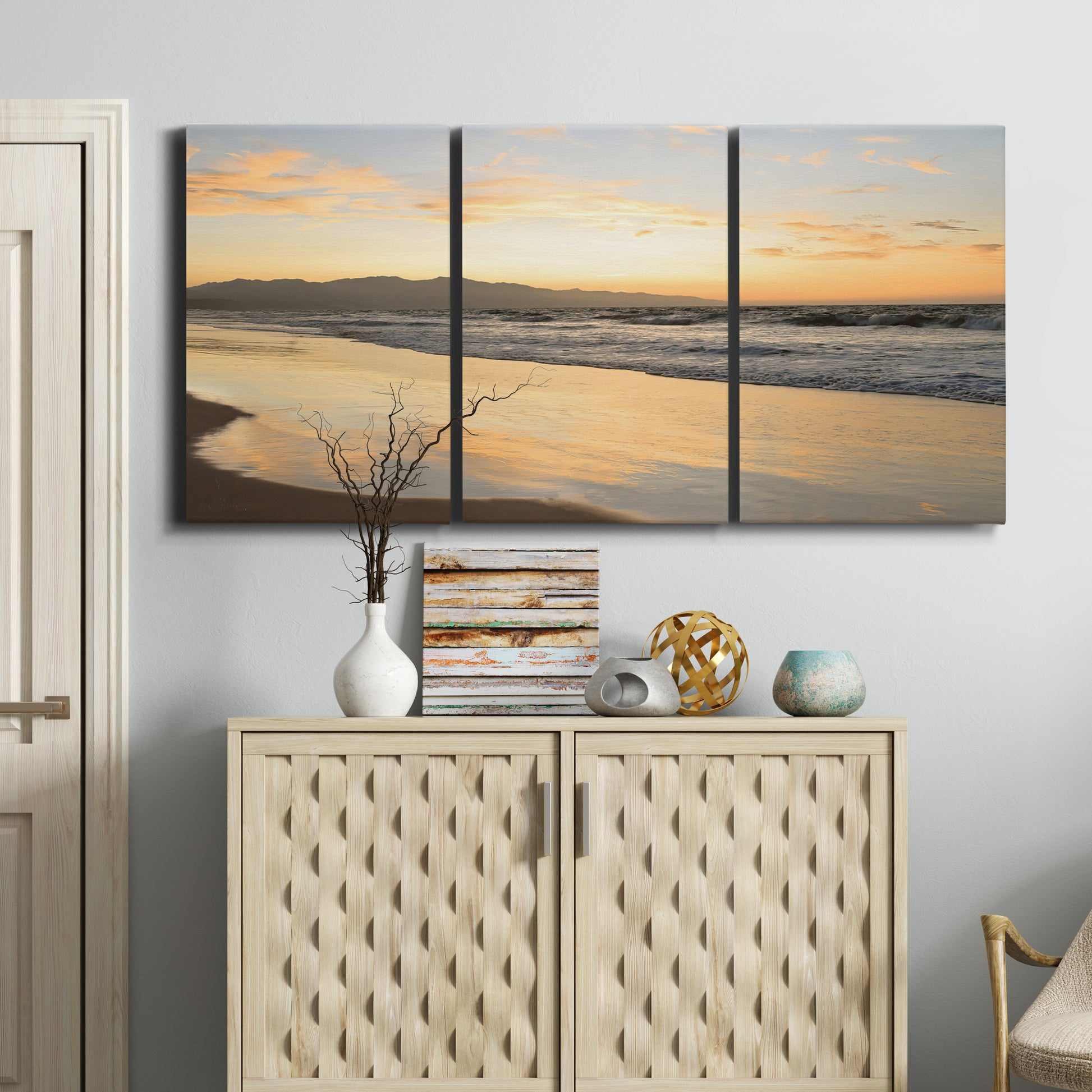 Three-panel canvas wall art featuring quiet tropical shoreline at low tide, displayed above a cabinet in an entryway.