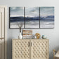 Three-panel canvas wall art featuring abstract coastal tones and movement, displayed above a cabinet in an entryway.