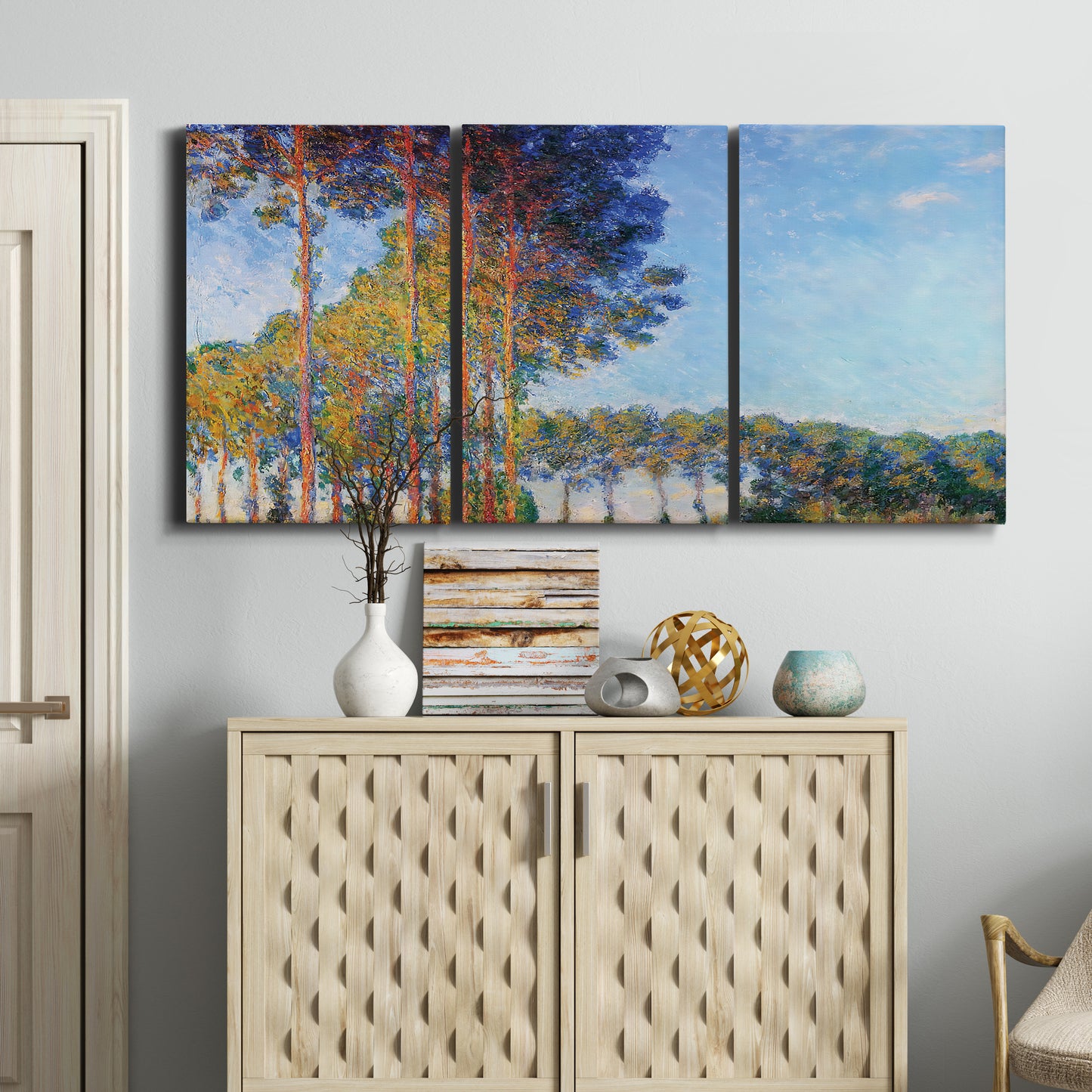 Three-panel canvas wall art featuring autumn poplar trees along river, displayed above a cabinet in an entryway.