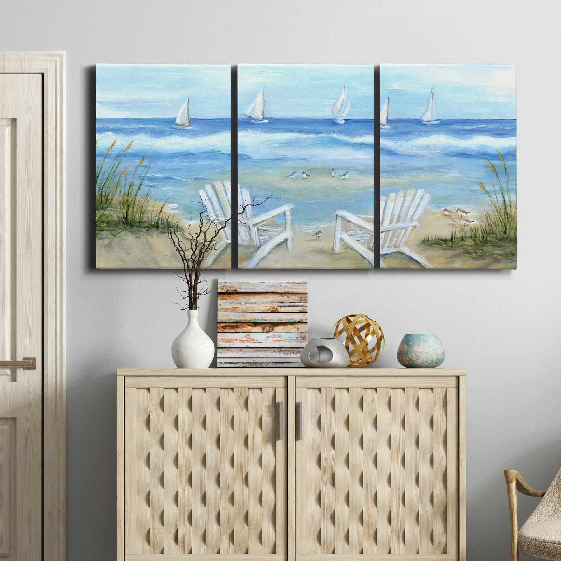 Three-panel canvas wall art featuring peaceful coastal landscape escape, displayed above a cabinet in an entryway.