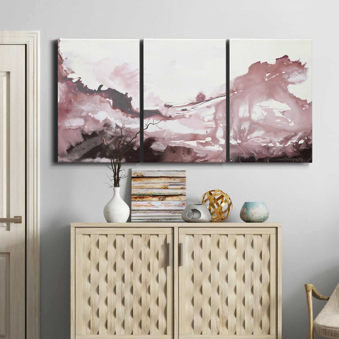 Three-panel canvas wall art featuring soft pink abstract scenic layers, displayed above a cabinet in an entryway.