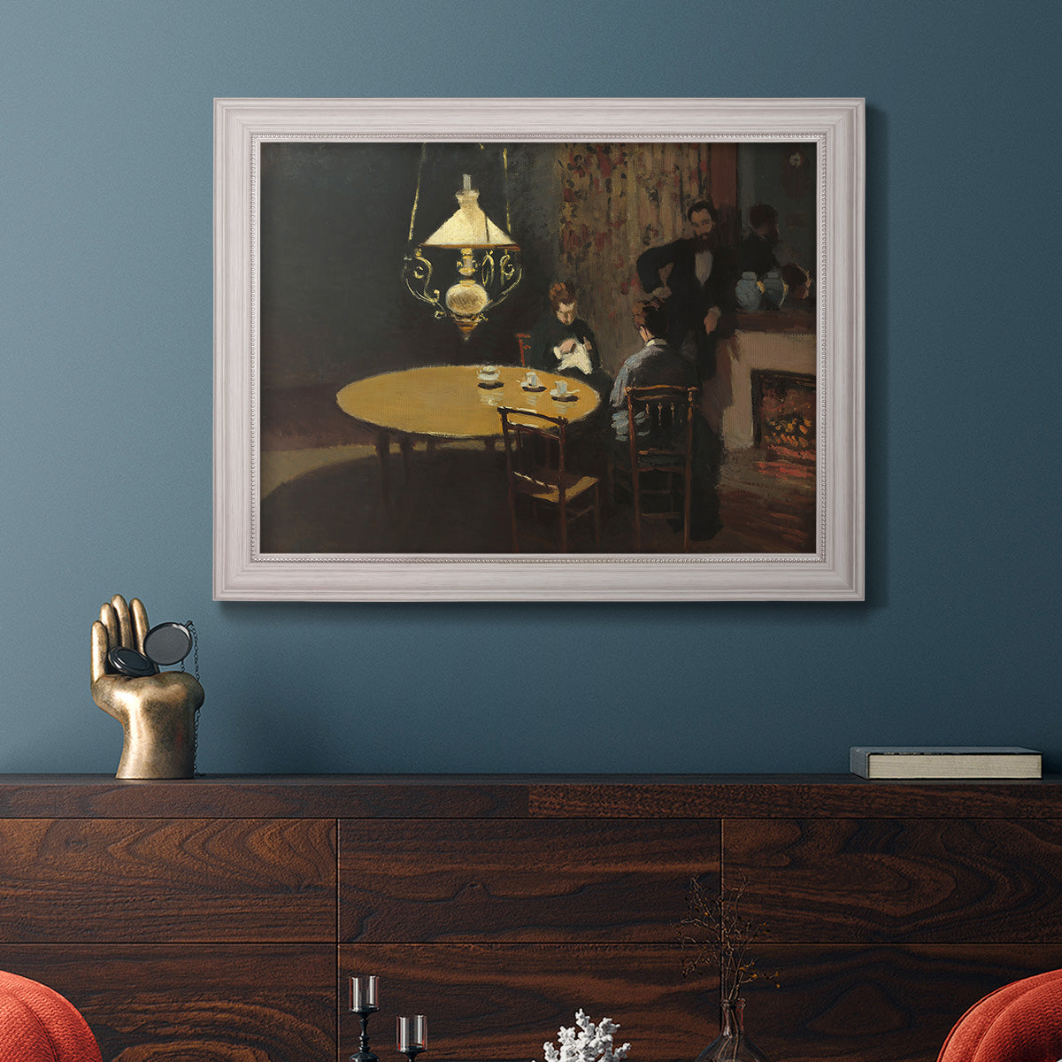 Impressionist domestic interior scene by Claude Monet in an ornate weathered white frame displayed in a dark-toned interior setting.