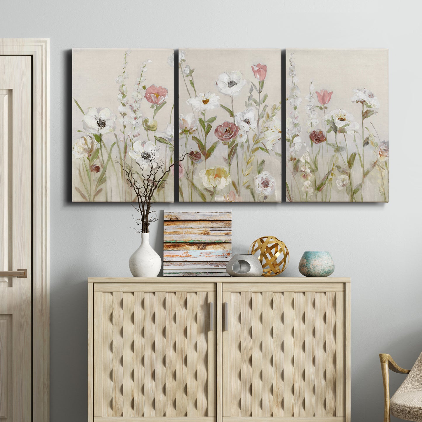 Three-panel canvas wall art featuring loose farmhouse style floral painting, displayed above a cabinet in an entryway.