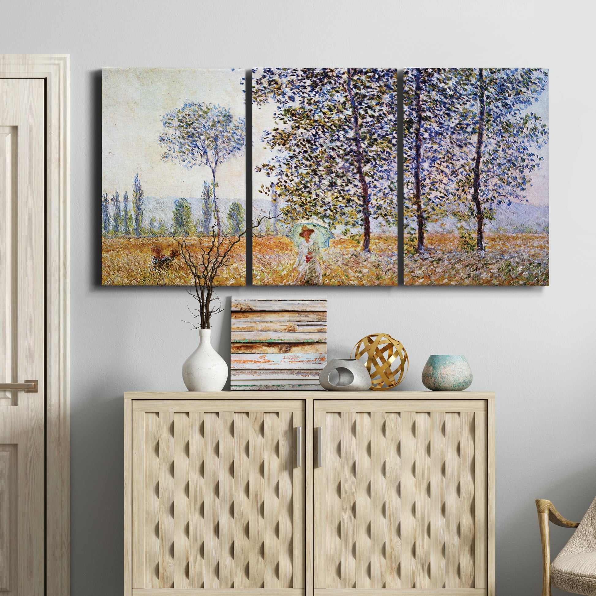 Three-panel canvas wall art featuring three poplar trees beside water, displayed above a cabinet in an entryway.