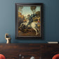 Religious painting of Saint George slaying the dragon by Raphael in an ornate black frame with gilded inner detail displayed in a dark-toned interior setting.