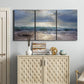 Three-panel canvas wall art featuring soft sunrise over open water, displayed above a cabinet in an entryway.