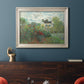 Impressionist garden landscape at Argenteuil by Claude Monet in an ornate champagne frame displayed in a dark-toned interior setting.