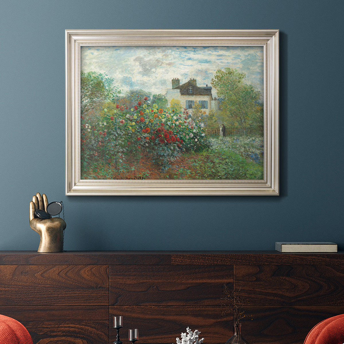 Impressionist garden landscape at Argenteuil by Claude Monet in an ornate champagne frame displayed in a dark-toned interior setting.