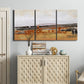 Three-panel canvas wall art featuring abstract bridge landscape in ochre, displayed above a cabinet in an entryway.
