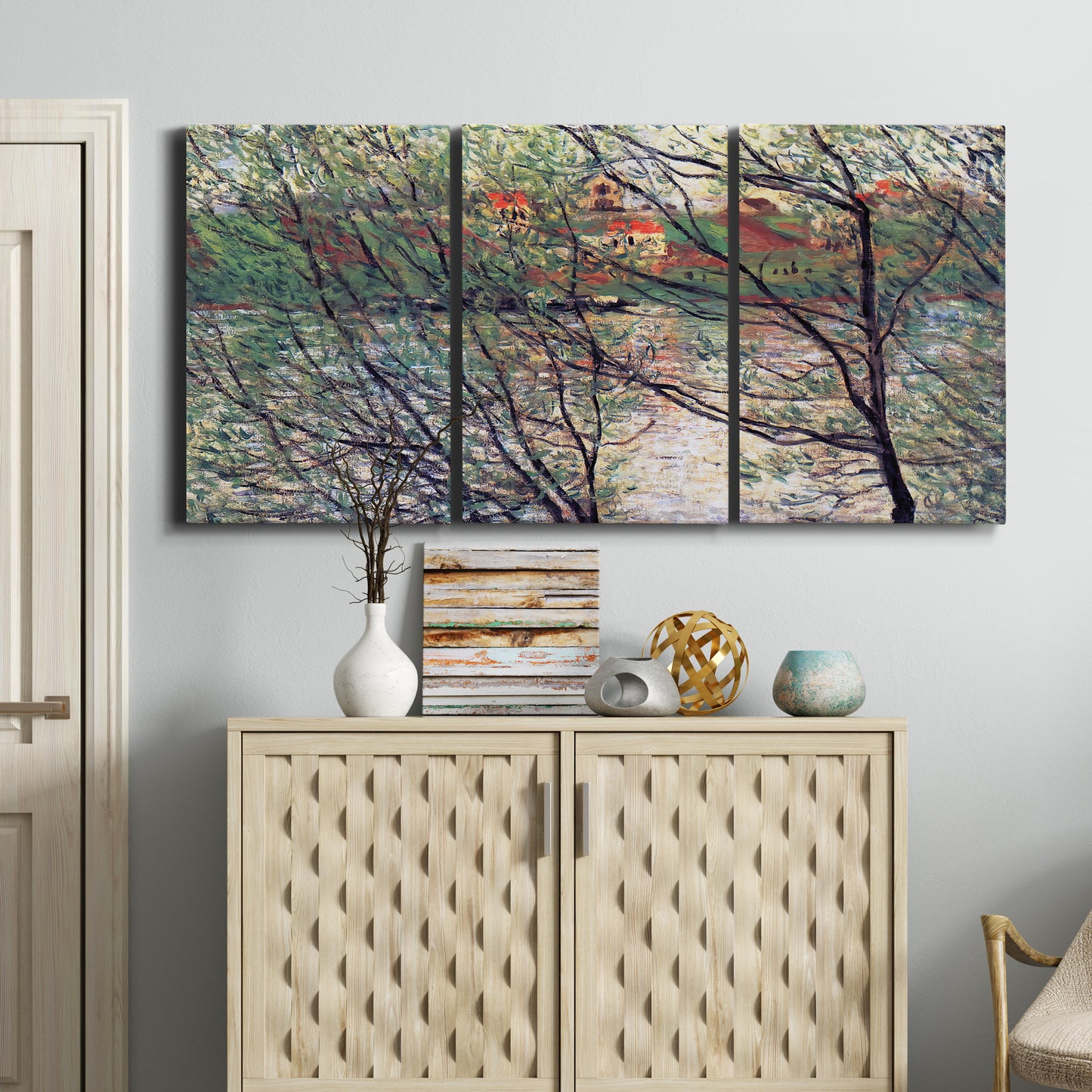 Three-panel canvas wall art featuring riverside park with figures and trees, displayed above a cabinet in an entryway.