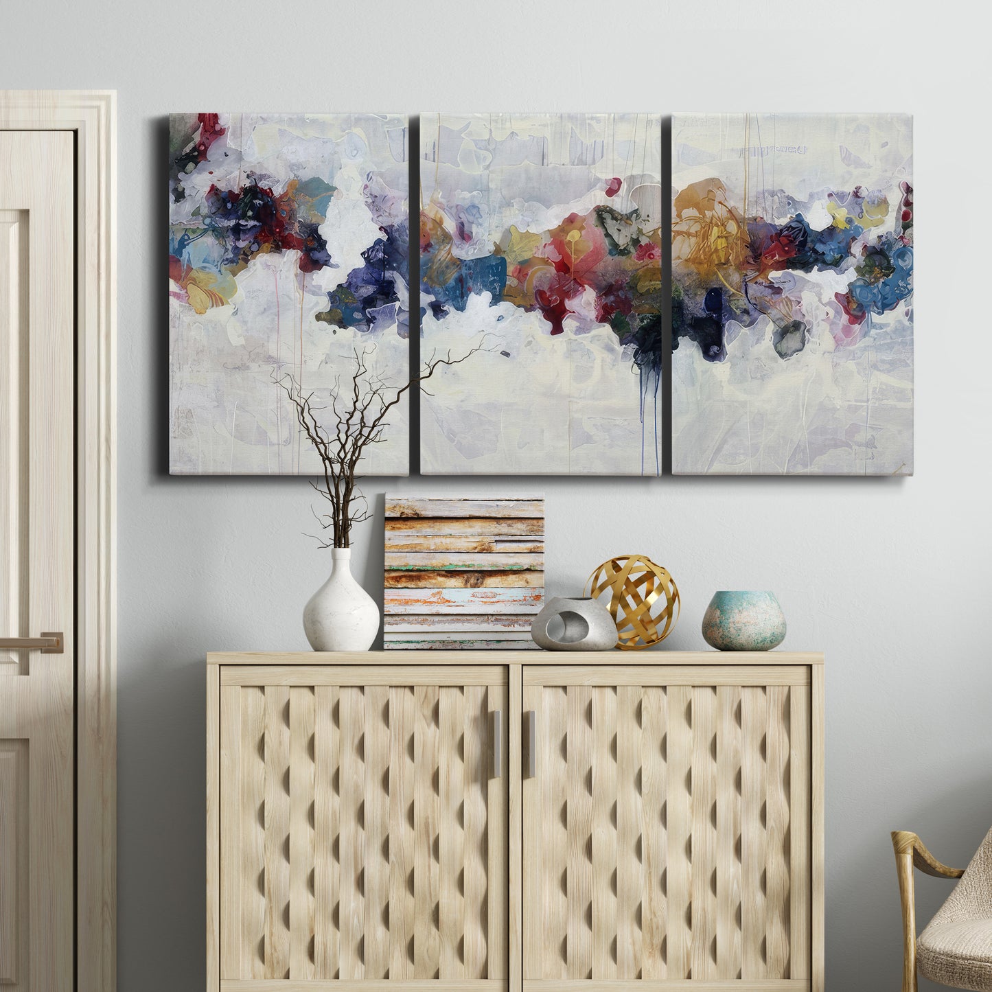 Three-panel canvas wall art featuring abstract water inspired composition, displayed above a cabinet in an entryway.