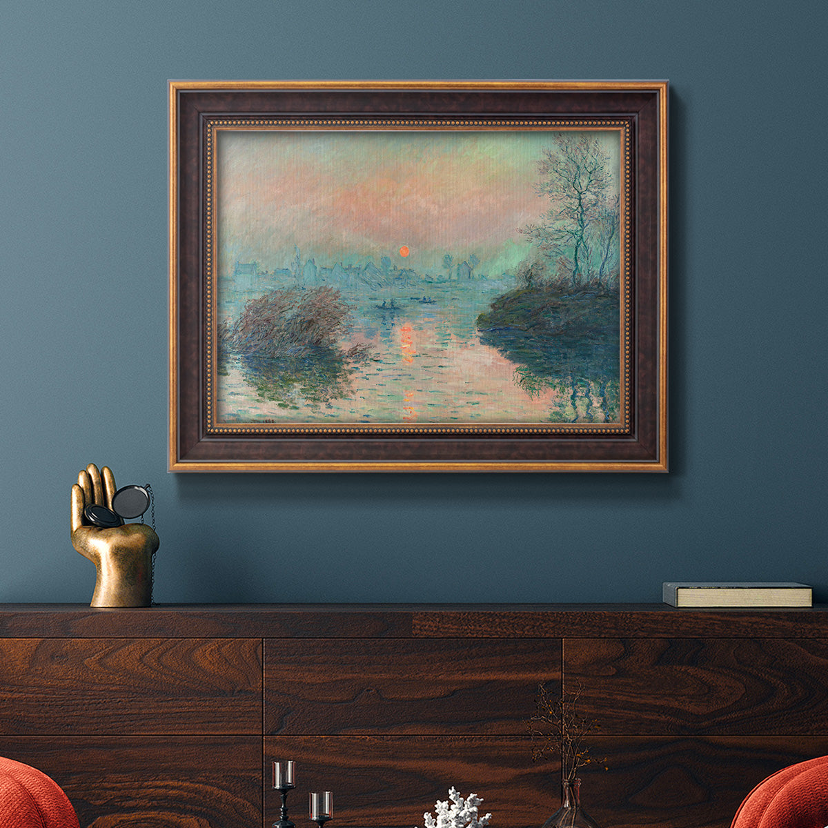 Impressionist winter river sunset scene by Claude Monet in an ornate bronzed mahogany wood frame displayed in a dark-toned interior setting.
