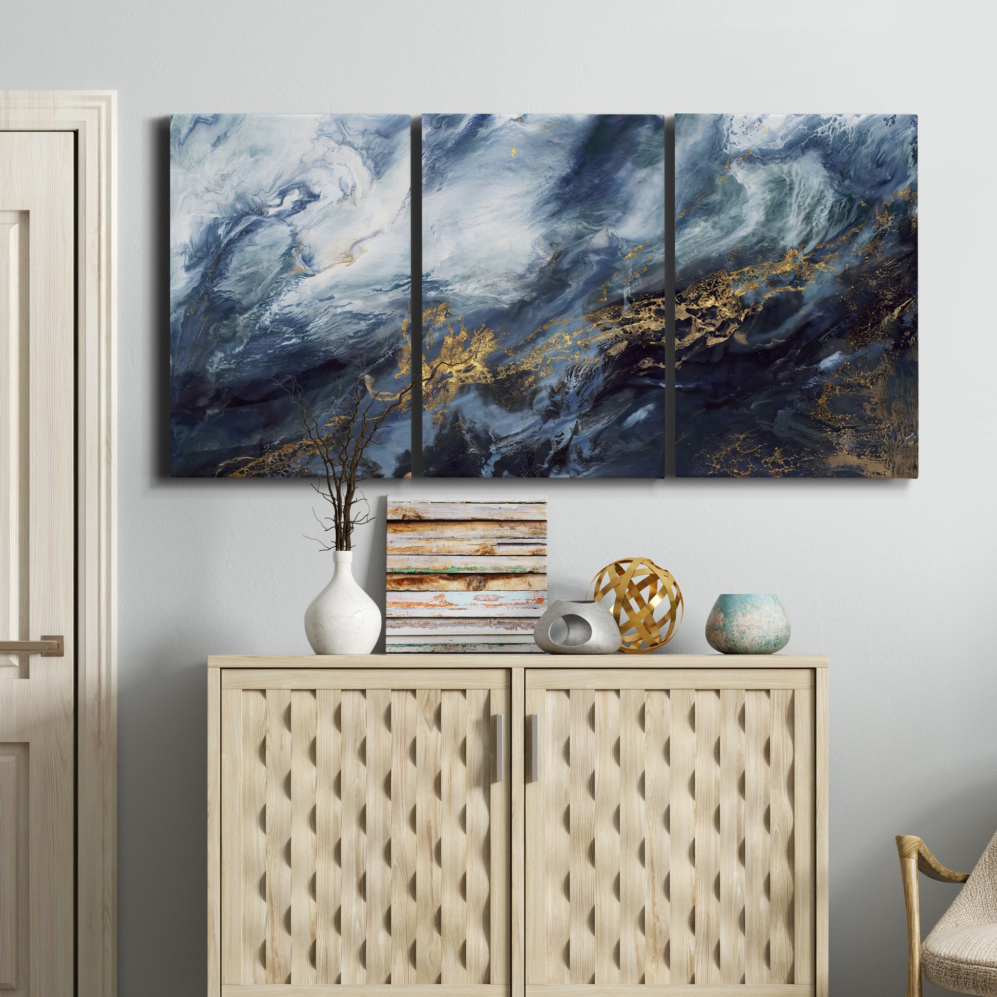Three-panel canvas wall art featuring soft abstract landscape anticipation tones, displayed above a cabinet in an entryway.