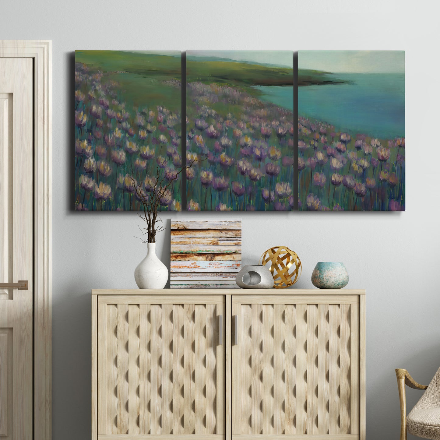 Three-panel canvas wall art featuring calm coastal landscape sanctuary, displayed above a cabinet in an entryway.