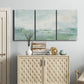 Three-panel canvas wall art featuring soft abstract coastal tones, displayed above a cabinet in an entryway.
