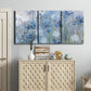 Three-panel canvas wall art featuring delicate watercolor floral blooms, displayed above a cabinet in an entryway.