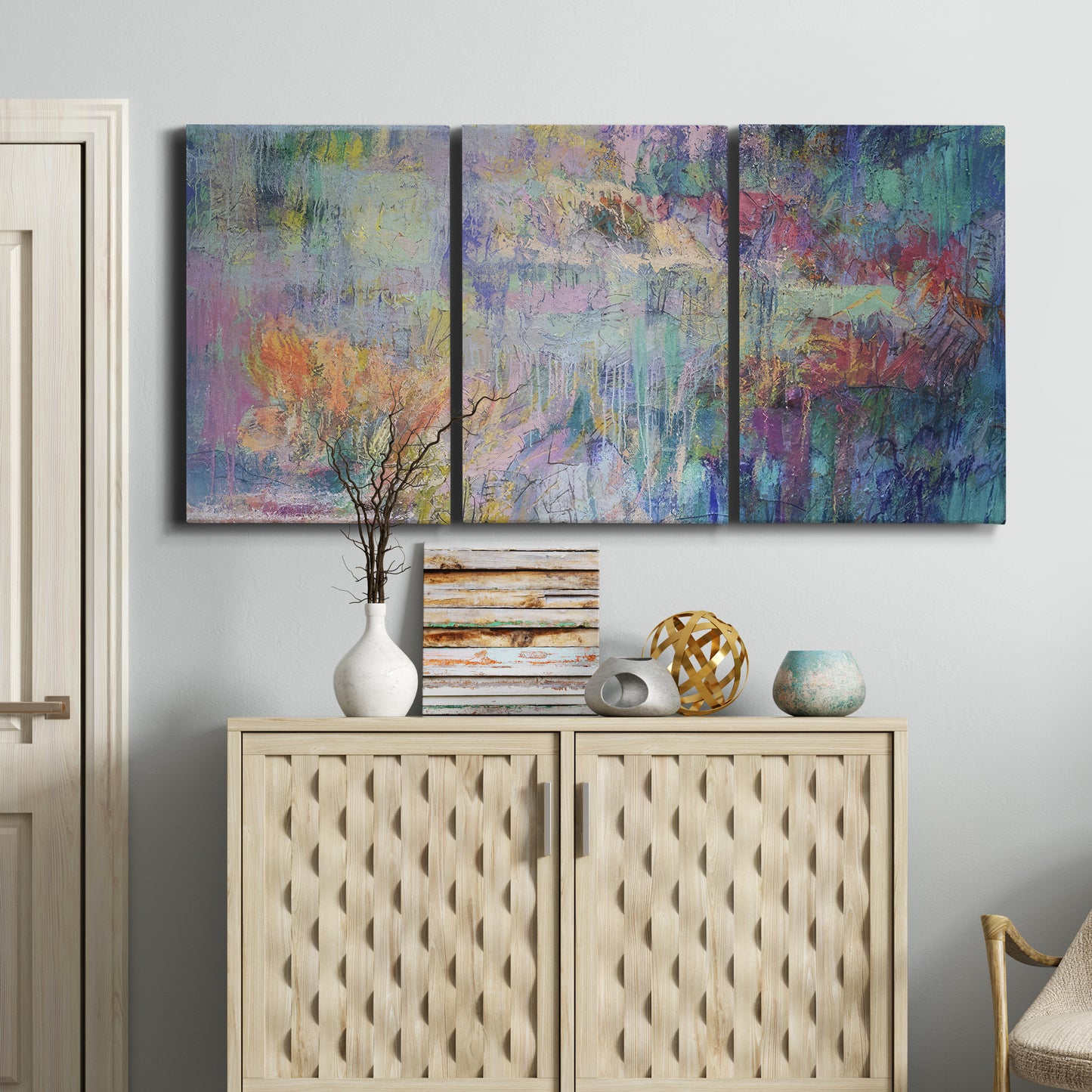 Three-panel canvas wall art featuring abstract evening landscape with depth, displayed above a cabinet in an entryway.
