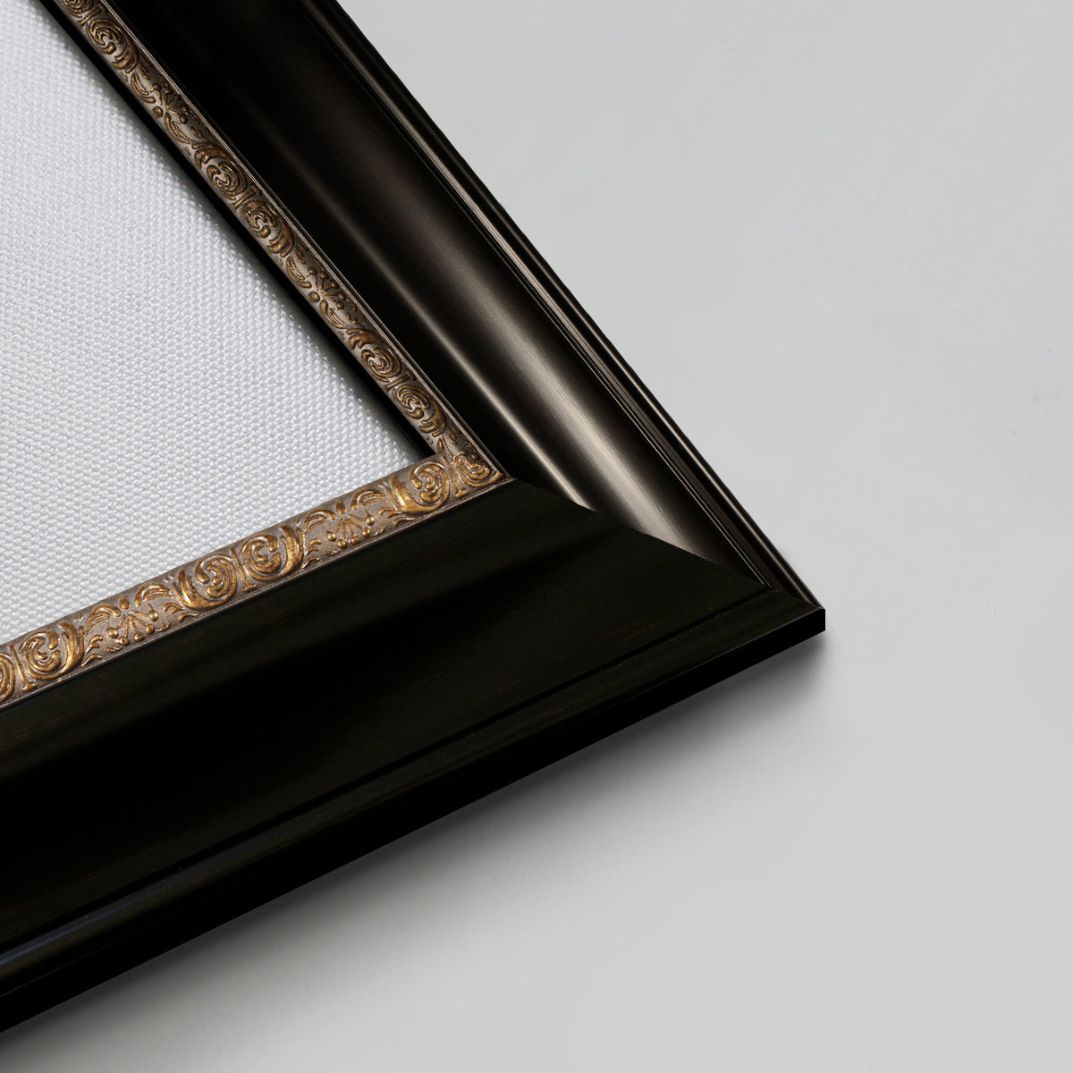 Detail of ornate black frame with gilded inner detail.